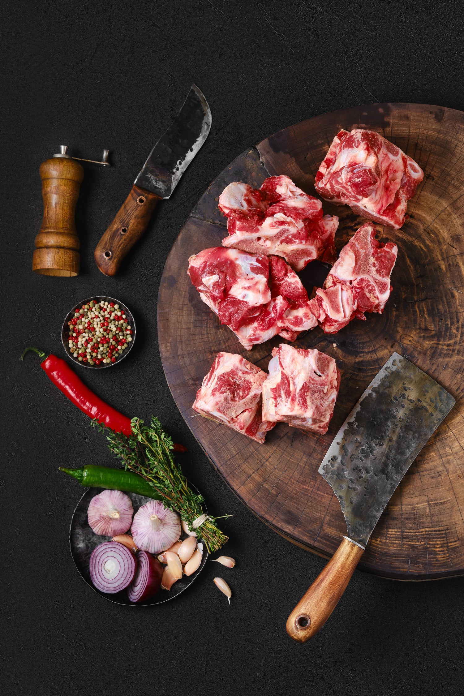 beef cuts on a wooden cutting board with a black background